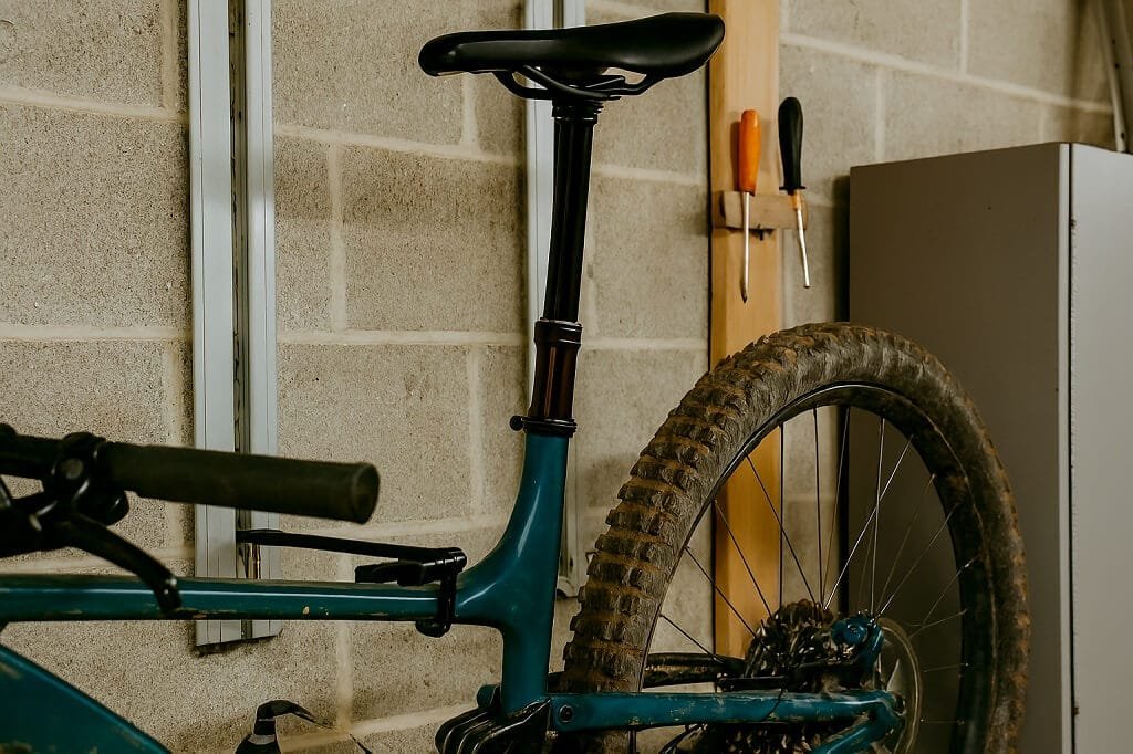 Bike stored upright in a garage with a clean dropper post